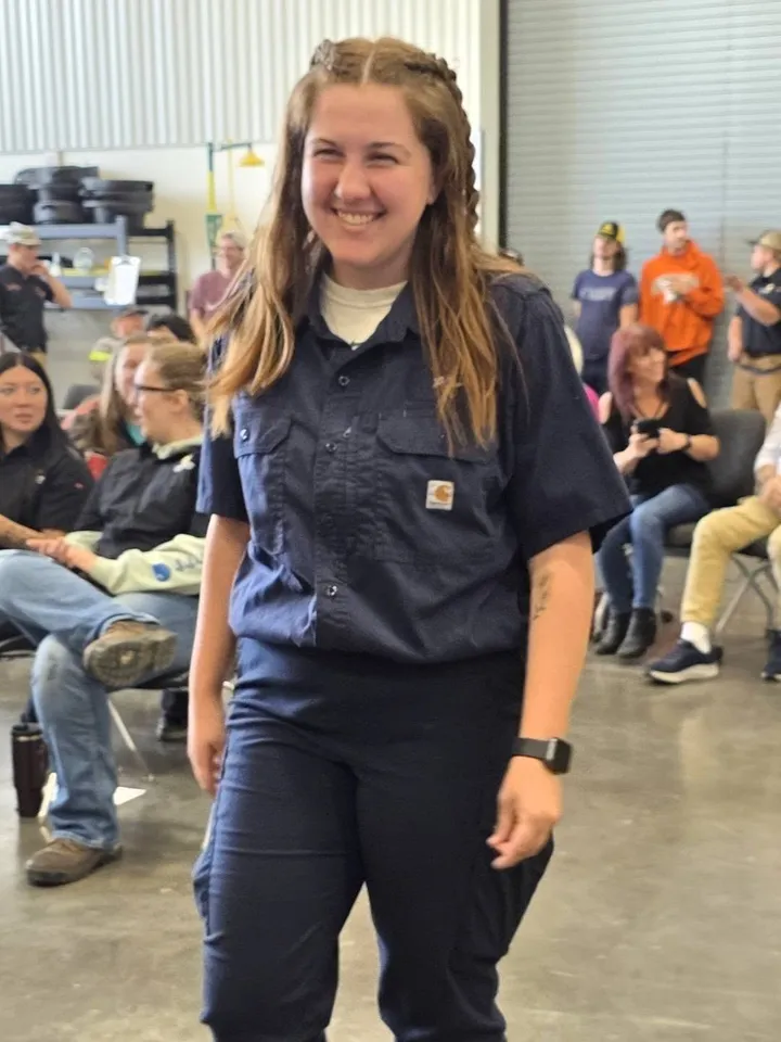 Jillian smiling in a navy work shirt at the LBCC Automotive Technology event