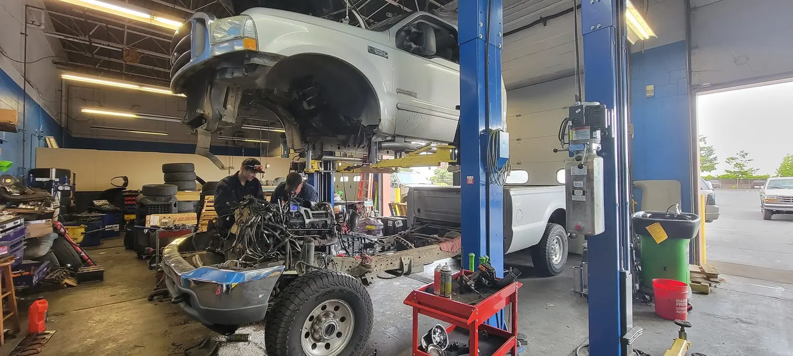 The RT Automotive shop floor: two blue lifts, a pickup in the air and the 1936 Chevy waiting by the door